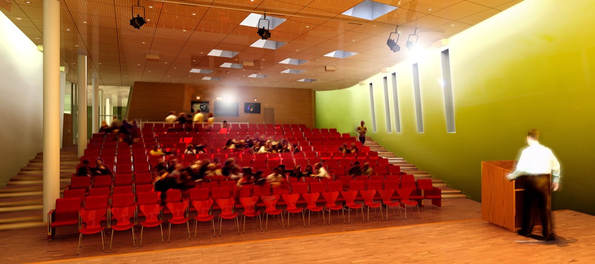 A rendered auditorium with tiers of red seats, a wood-slat ceiling with skylights, a green end wall, a speaker at a lectern