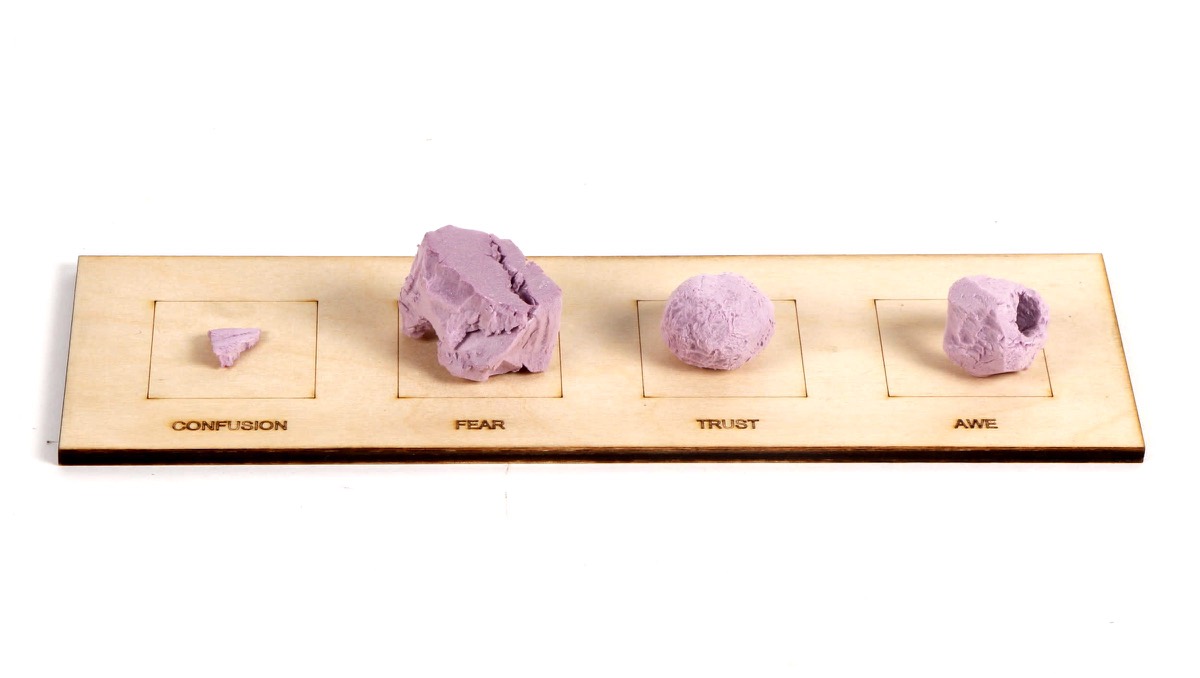 Four small lilac forms in a laser-engraved plywood tray labelled with the four words