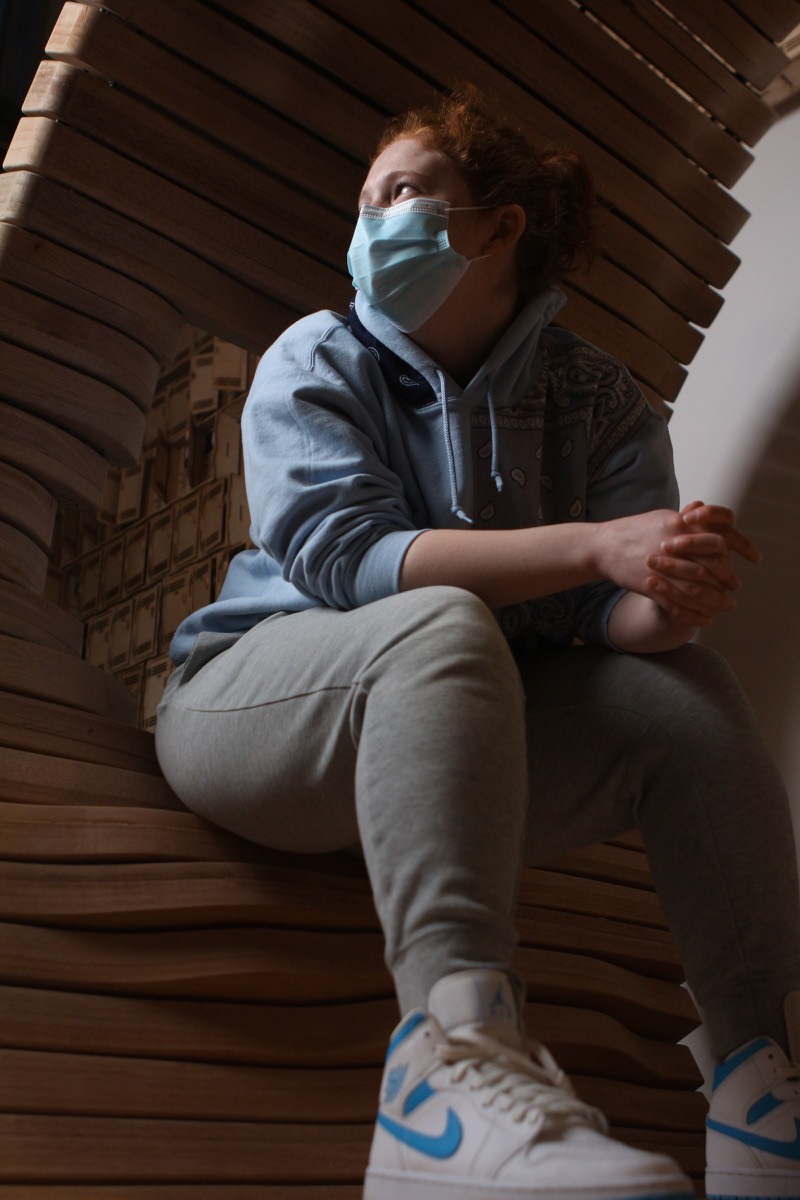 A student inside the plywood ribs, looking out