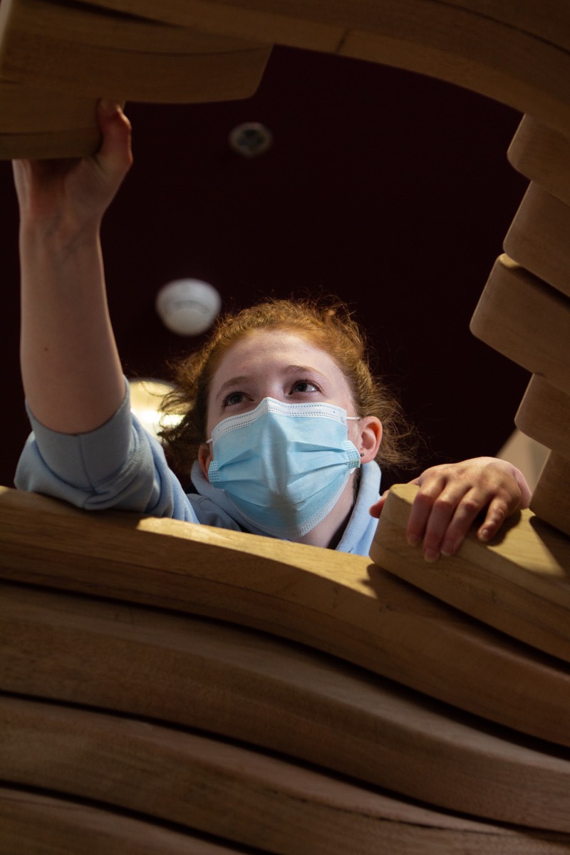 A student lifting a plywood rib into position