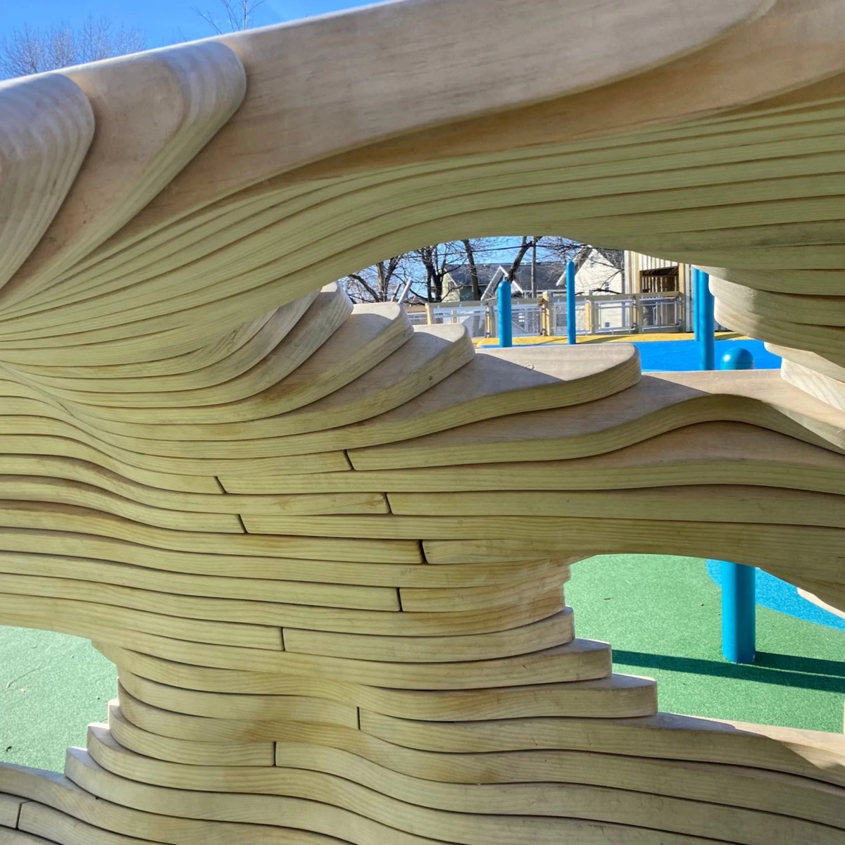 A close oblique of the wave-cut planks with the blue play surface through an opening