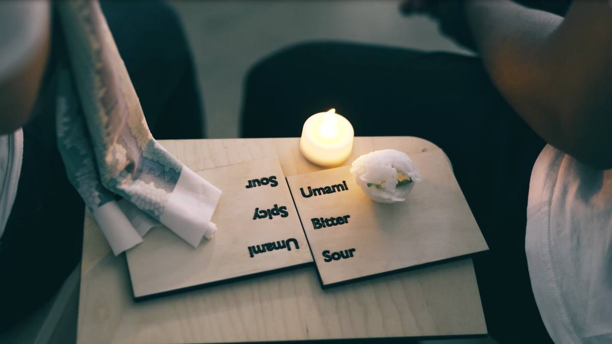 A wooden tray with labelled tasting cups and a candle