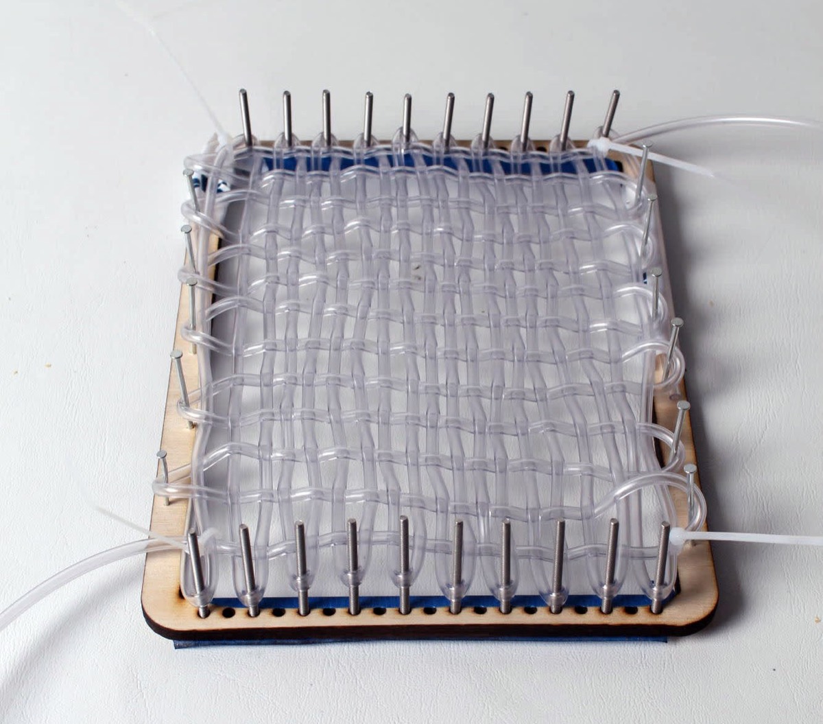 Clear tubing woven on a plywood jig with pins