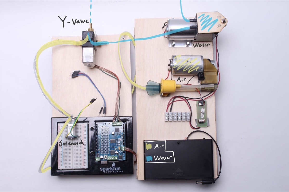 A valve-and-pump rig on a plywood board with an Arduino and tubing
