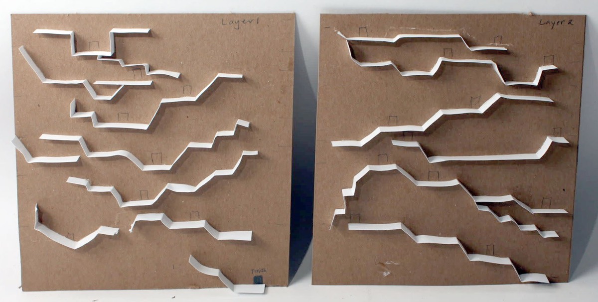 Two chipboard sheets cut with branching tunnels